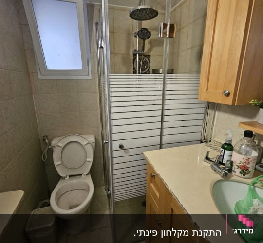 חדר אמבטיה עם מקלחון, כיור ושירותים